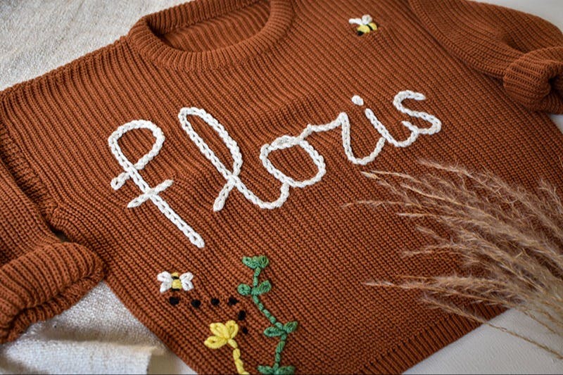 Een trui met de naam Floris met bloemetjes en bijtjes